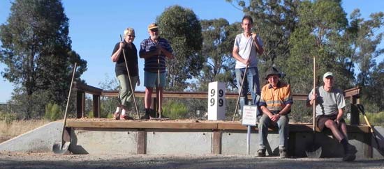 Five people with shovels posing on the new replica platform